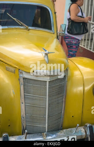 Cuba Trinidad classic vintage old car Ford Prefect 4 door saloon painted gold yellow circa 1951 parked cobbled street detail Stock Photo