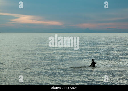 A solitary fisherman hitting water in Kep, Cambodia, Asia. Stock Photo