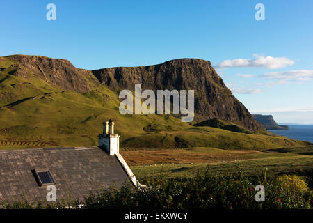 Looking over a house, toward Waterstein Head from the road on the way to Neist Point Lighthouse on the Isle of Skye. Stock Photo