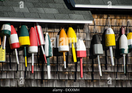 Brightly painted lobster buoys hang from the eaves of a seaside cottage. Stock Photo