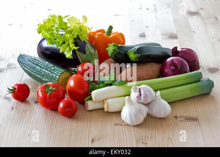Fresh vegetables on a sunlit kitchen table background. A food still-life group of a selection of fresh vegetables. Stock Photo