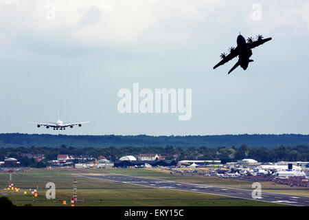 Airbus A380 landing while Airbus A400M Atlas takes off for a display at Farnborough International Airshow 2015 Stock Photo