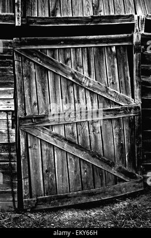 Weathered wooden door with rusty lock. Old farmhouse in Olivenza, Spain. Black and white. Stock Photo