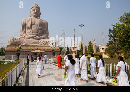 Pilgrims walk towards the Great Buddha statue at Bodhgaya Stock Photo