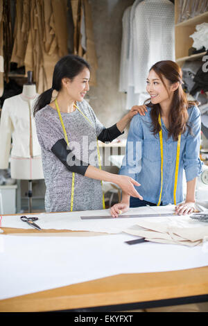 Two female fashion designers talking in studio Stock Photo