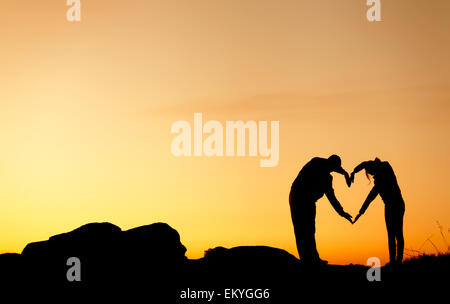 Conceptual heart shape, symbol of human. Woman and man hand silhouette ...
