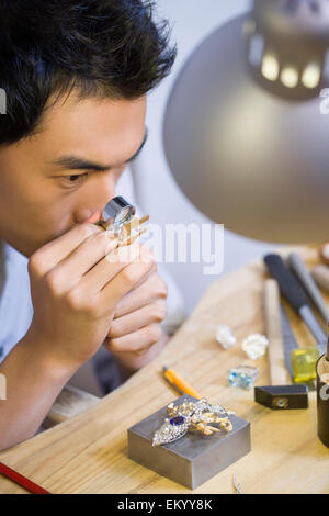 Male jeweler examining a diamond with loupe Stock Photo