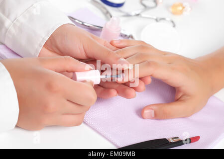 Manicure. Care of fingers of hands, cleaning, covering a varnish of nails. Stock Photo