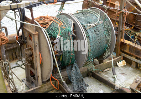 Fishing net and winding mechanism on trawler boat moored in Looe harbour, Cornwall, England Stock Photo
