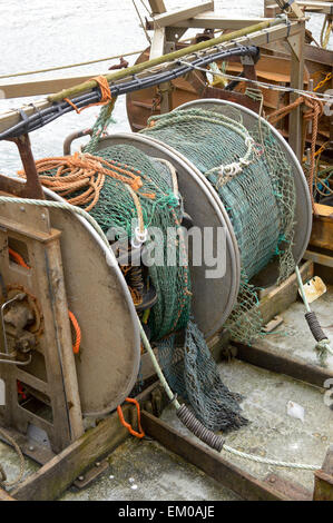 Fishing net and winding mechanism on trawler boat moored in Looe harbour, Cornwall, England Stock Photo