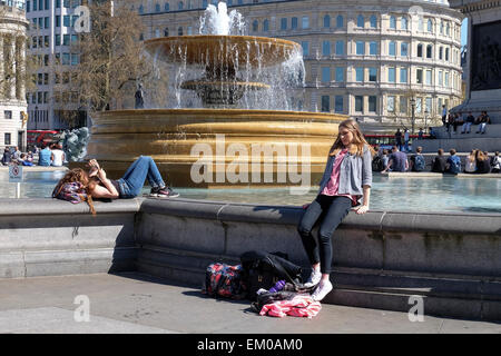 Trafalgar Square, London, UK. 14th April, 2015. Two young women relax in the sunshine as Londoners and tourists enjoy the parks and public spaces as temperatures rise in Spring. Credit:  Eden Breitz/Alamy Live News Stock Photo