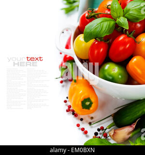 Assorted tomatoes and vegetables in colander Stock Photo