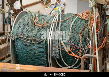 Fishing net and winding mechanism on trawler boat moored in Looe harbour, Cornwall, England Stock Photo