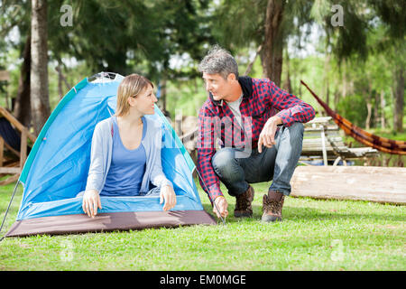 Loving Couple Setting Up Tent In Park Stock Photo