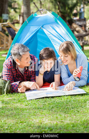 Happy Family Reading Map In Tent Stock Photo