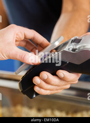 Man Paying Through NFC Technology At Cinema Stock Photo