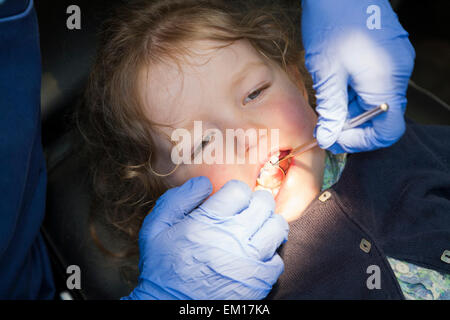 Toddler girl / 2 or 3  yr / two or three year old child during check up with childrens dentist / children's dental practice. UK Stock Photo
