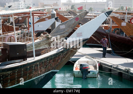 A man walks the amid traditional dhow boats at the wharf in Doha, Qatar. Stock Photo