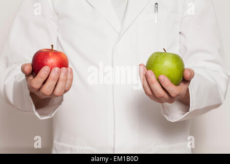 Doctor holding two apples in hand Stock Photo