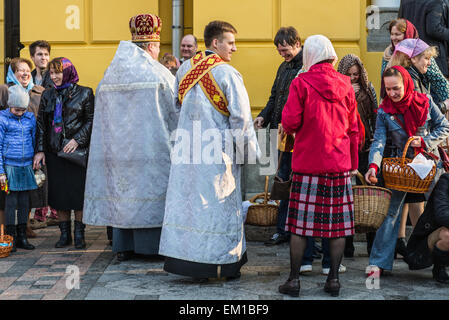 Priest blessing the happy people during Holy Easter Sunday ceremony outside St Volodymyr's Cathedral in Kiev Stock Photo