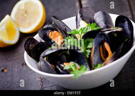 Fresh mussels in a bowl with wine and herbs Stock Photo