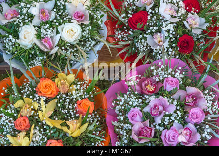 Different colour bouquets of cut flowers and foliage on display on a market stall Stock Photo