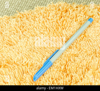 Blue Pen on Orange Hair Fur Carpet on a Mat Stock Photo