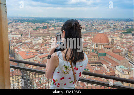 Woman tourist Italy, a solo female tourist takes a photo of the Florence skyline from the observation platform on the Cathedral dome, Firenze, Italy. Stock Photo