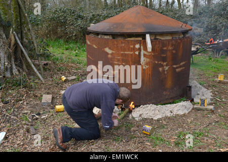 A charcoal kiln being lit in a deciduous woodland in southern England Stock Photo
