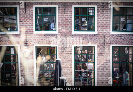 Leiden, Netherlands. 15th April, 2015. People can be seen at work in the library of Leiden while beneath reflected in the windows people are seen enjoying the sun on a terras. Credit:  Jaap Arriens/Alamy Live News Stock Photo