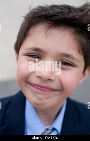 Seven year old boy goofs around in his new suit Stock Photo