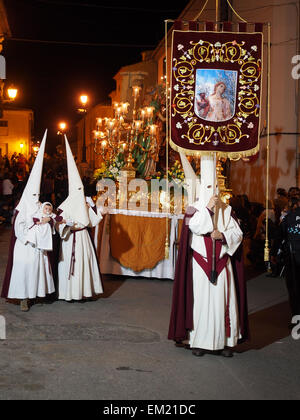 Nazarenos (penitents) walking in a night time procession during Semana Santa (Holy Week) in Hellin, Spain Stock Photo