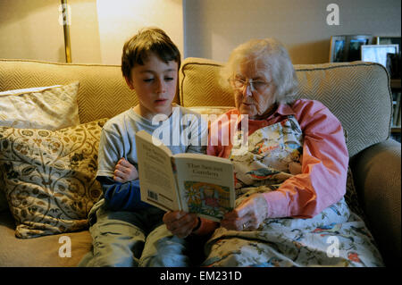 Grandparent listening to her grandson reading The Secret Garden Stock Photo