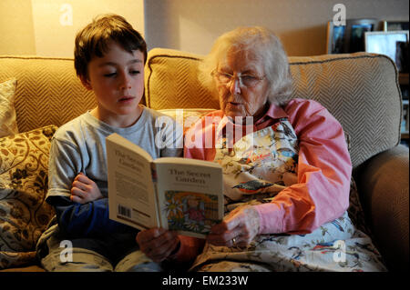 Grandparent listening to her grandson reading The Secret Garden Stock Photo