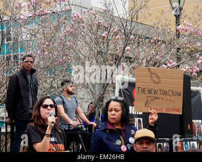 New York, USA. 14th Apr, 2015. Speaker and organizers discuss future actions as one women hold sign calling the current system 'The New Jim Crow'. Protesters gathered in New York City and around the United States to rally against police brutality and a peak in officers killing unarmed black men. Organizers spread the message on social media using the #ShutDownA14 hashtag. © Mark Apollo/Pacific Press/Alamy Live News Stock Photo