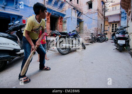 Boys playing cricket on the street Stock Photo