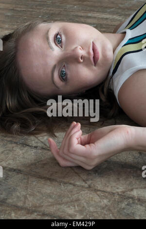 Beautiful young woman lying on the floor Stock Photo