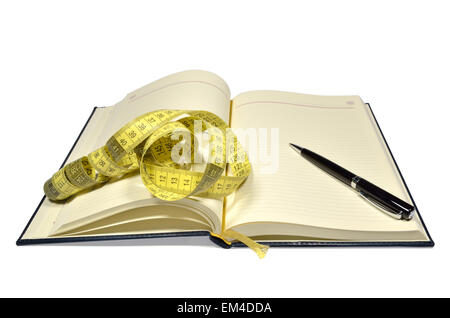 Open planner with yellow measuring tape and black pen Stock Photo