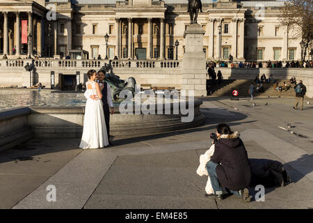 Newly married yYoung couple having wedding photos taken at Trafalgar Square in London, UK Stock Photo
