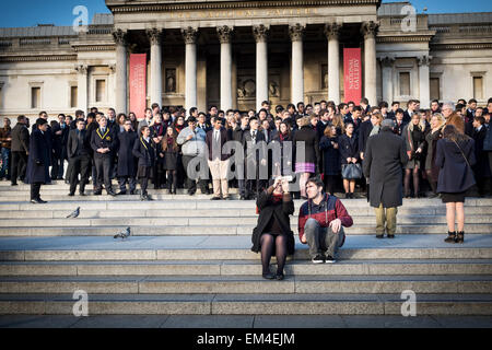 A couple taking selfie in front of young students for group photos, Trafalgar Squre, London, UK