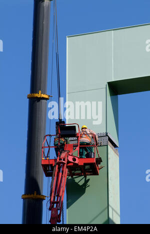 Two Worker installing a metal bridgehead in a harbor Stock Photo