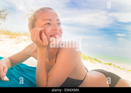 Happy woman in bikini on the beach.