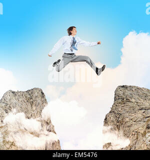 Businessman jumping over gap Stock Photo