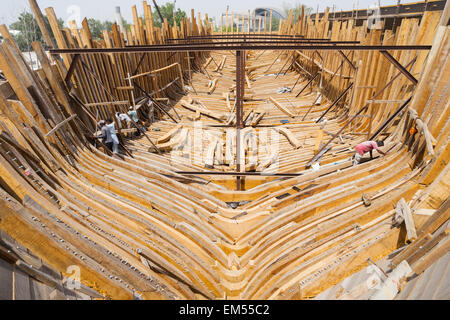 Building a traditional wooden dhow cargo ship in shipyard beside The Creek River in Dubai United Arab Emirates Stock Photo