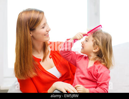 happy mother and daughter with comb Stock Photo