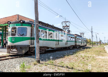 Working green and grey old electric gauge train bought from Spain on a railway track at a station in a remote part of Cuba Stock Photo