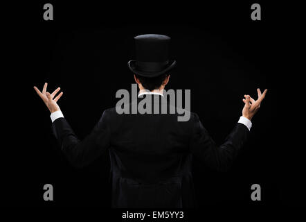 magician in top hat showing trick from the back Stock Photo