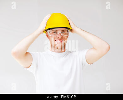 male builder in safety glasses and yellow helmet Stock Photo