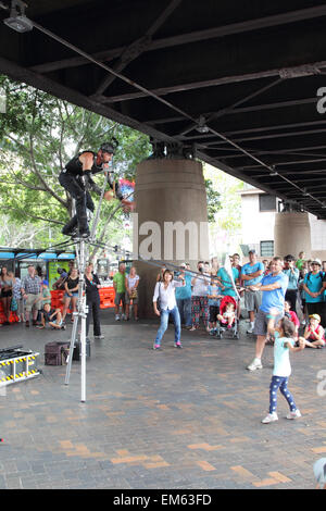 Street Artist juggling with burning torches during a performance at  Circular Quay, Sydney, Australia. Stock Photo