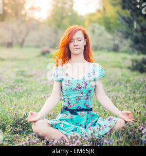 Young woman doing yoga in Park Stock Photo